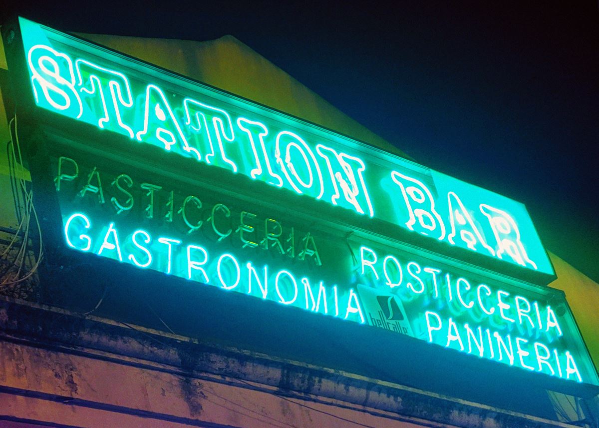 Neon sign of a station bar in Italy at night